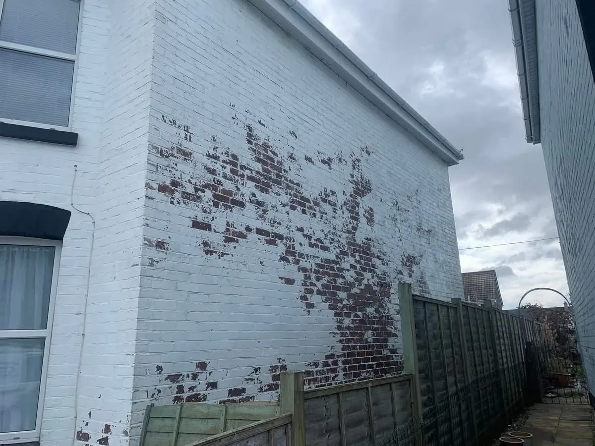 Peeling paint on a brick wall before redecoration in St Stephen in Brannel
